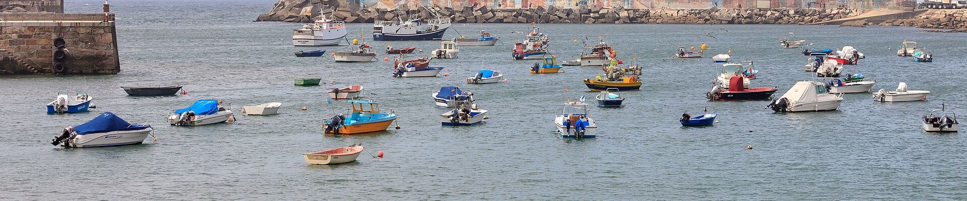 Embarcaciones fondeadas en el puerto de A Guarda, con el espigón y el dique de abrigo al fondo